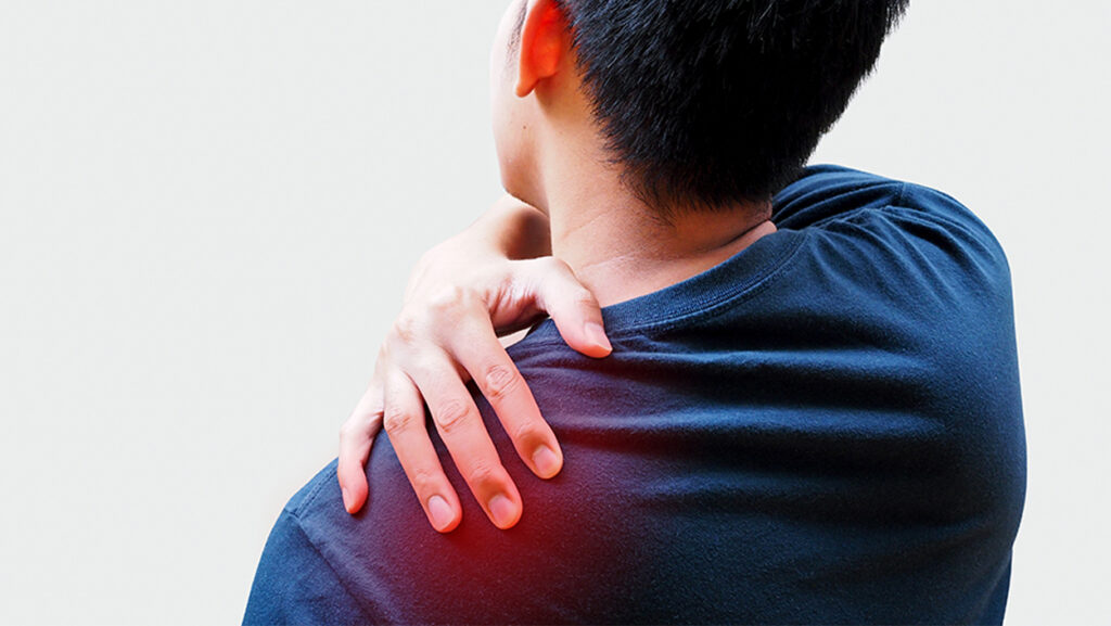 Young Asian man suffering from back pain, shoulder pain and office syndrome.